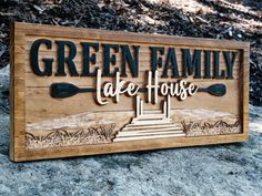 a wooden sign that says green family cafe house on the side of a hill with two oars