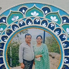 two people standing in front of a blue and white circular frame