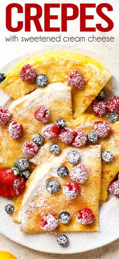 crepes with powdered cream and berries on a white plate, topped with powdered sugar