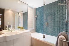 a bath room with a sink a mirror and a bath tub next to each other