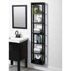 a bathroom with a sink, mirror and shelving unit next to the wall holding towels