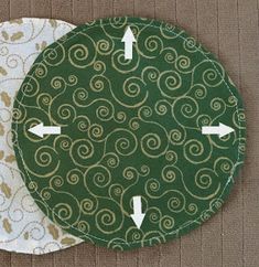 two circular coasters with arrows pointing to each other on a brown tablecloth background