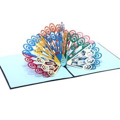 a folded card with an intricately designed fan on the front and sides, in multi - colored paper