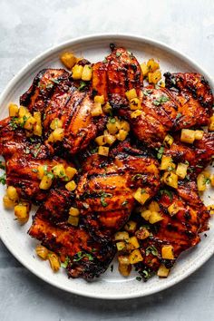 grilled chicken with pineapple salsa on a white platter, ready to be eaten