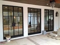 an open patio with sliding glass doors and wood pallets on the ground next to it