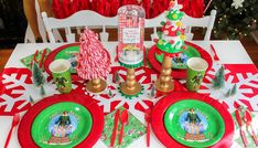 a table set for christmas with plates, napkins and candy canes