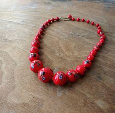 "Vintage glass bead necklace/choker, glass beads are descending in size and are hand knotted between each. Each bead has colorful striped \"balls\" on them that look like little sea urchins. Circa 1940's - 50's (possibly earlier), marked Japan on hook clasp. Largest bead is approx. 3/4\". Necklace is in good condition, please see photos. Offbeat Avenue uses recycled packaging when available." Retro Wooden Bead Jewelry, Retro Wooden Round Bead Jewelry, Vintage Wooden Beads Necklace, Vintage Jewelry With Wooden Round Beads, Vintage Wooden Round Beads, Vintage Glass Beaded Necklaces With Colorful Beads, Retro Large Beads For Gifts, Handmade Retro Red Beaded Necklaces, Retro Beaded Necklace With Colorful Round Beads