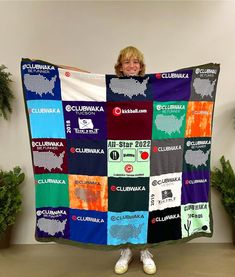 a woman is holding up a quilt made out of t - shirts