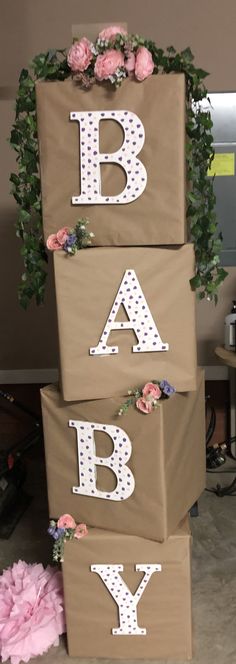 three brown boxes with white letters and pink flowers are stacked on top of each other