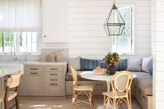 a kitchen with white walls and wooden flooring next to a breakfast nook table