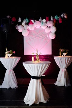 the tables are decorated with pink and white pom poms