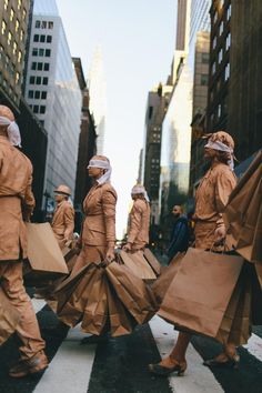 some people are walking down the street with bags on their heads and wearing protective gear