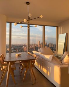 a living room filled with furniture and a large window covered in lots of windows overlooking the city