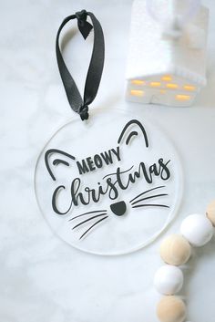 a glass ornament that says merry christmas with a cat's head on it