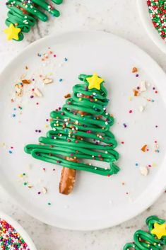 a green christmas tree shaped pretzel on a white plate with sprinkles