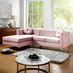 a living room with a pink couch and coffee table in front of a large window