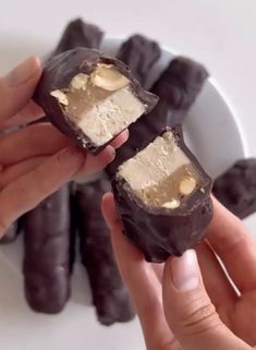 two hands holding pieces of chocolate covered in peanut butter