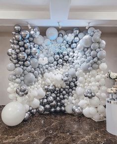 balloons and streamers are arranged on the wall for an elegant balloon display at a birthday party