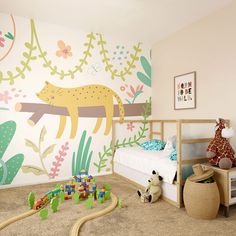 a child's bedroom decorated in pastel colors with jungle animals on the wall