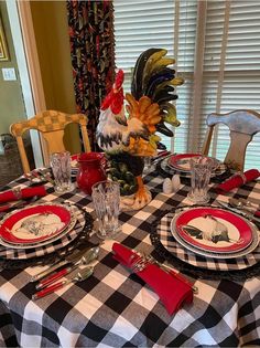 a rooster statue sitting on top of a black and white checkered table cloth covered dining room table