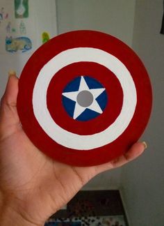 a person holding up a paper plate with a captain's shield on it in their hand