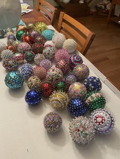 a table topped with lots of different colored balls on top of a white table cloth