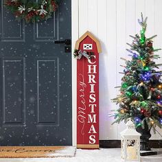 a decorated christmas tree next to a door with a sign that says, merry christmas