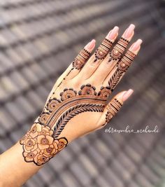 a woman's hand with henna tattoos on it