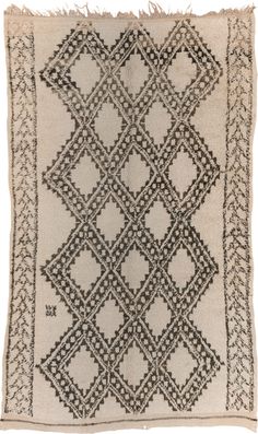 a black and white rug with fringes on the edges, in an ornate pattern