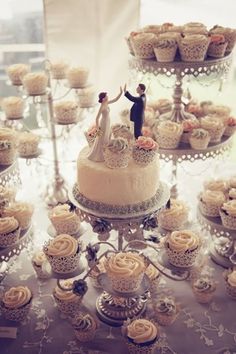 a table topped with lots of cupcakes covered in frosting