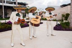 three men wearing sombreros and holding guitars