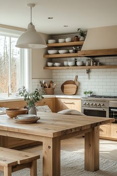 a wooden table sitting in the middle of a kitchen next to a stove top oven