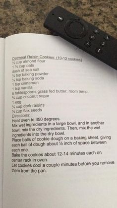 an open book with instructions on how to cook cookies in the microwave and tv remote control