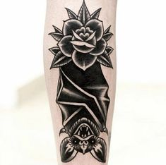 a black and white tattoo on the leg of a person with a flower in it