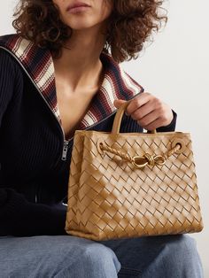 Bottega Veneta's leather 'Andiamo' tote has a retro shape that's perfectly sized to hold a few everyday essentials, like your phone, wallet and a book, on the morning commute. It's been made in Italy using the label's signature intrecciato technique and embellished with a gold-tone knot. Andiamo Bag Outfit, Elegant Woven Leather Shoulder Bag For Work, Luxury Woven Leather Bag For Work, Elegant Shoulder Bag With Braided Handles For Work, Gold Luxury Bag With Woven Leather, Leather Bags With Braided Handles For Work, Leather Work Bag With Braided Handles, Leather Bag With Braided Handles For Work, Gold Leather Bag With Woven Detail