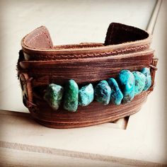 a leather cuff with turquoise beads on it