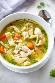 a white bowl filled with chicken noodle soup