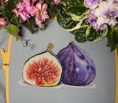 two figs on a blue cloth with purple flowers in the background and yellow trim