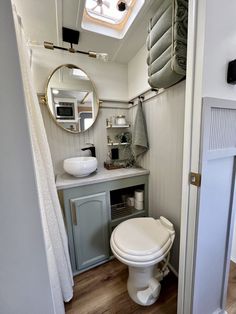 a white toilet sitting in a bathroom next to a sink