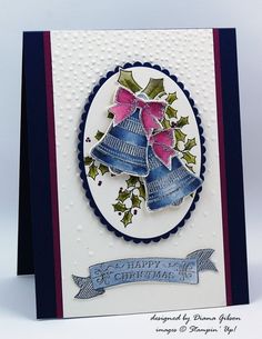 a handmade christmas card with bells and holly on the top, blue ribbon around the edge