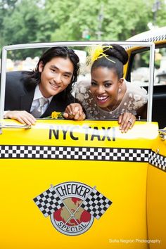 two people are posing in the back of a taxi