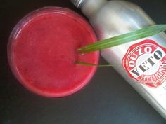 a red drink sitting next to a metal bottle