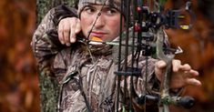 a young man is aiming with his bow