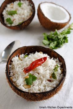 two coconut bowls filled with white rice and garnished with red pepper, cilantro, and parsley