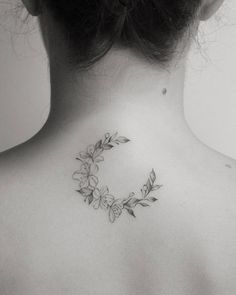 a woman's upper back tattoo with flowers and leaves on her left side ribcage