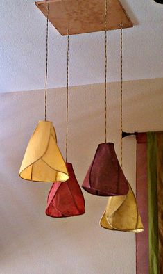 three different colored lamps hanging from a ceiling