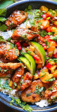 a blue bowl filled with chicken and vegetables