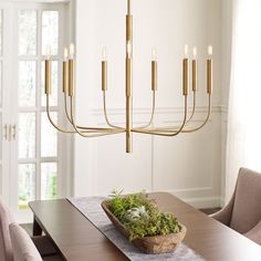 a dining room with a wooden table and gold chandelier