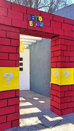 a red and yellow building with question marks on it's front door that is made out of cardboard