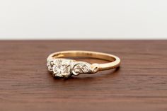 an old diamond ring sitting on top of a wooden table